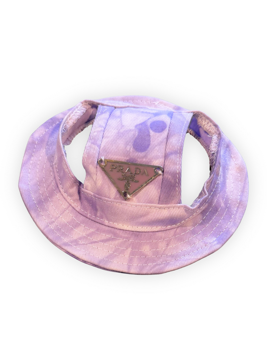 Small dog wearing lightweight bucket hat with ear openings and adjustable chin strap